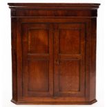An early 19th Century oak hanging corner cupboard,