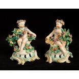 A pair of Bow porcelain seated cherub candlestick bases, circa 1765,