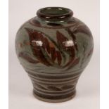A studio pottery vase, the grey ground with red detail and decorated leaves,