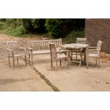 A teak slatted folding garden table, 100cm wide, four matching armchairs and a slatted garden seat,