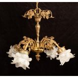 A brass four-branch scrolling electrolier on a central baluster column with floral swags and