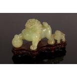 A celadon jade caving of a foo dog and young, 20th Century, Taishi Shaoshi,