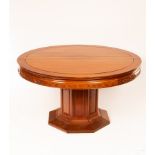 A Chinese circular dining table, the plain top above a carved frieze on an octagonal pedestal base,