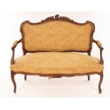 A Victorian carved walnut framed settee with scroll cared crest rail, upholstered back,