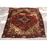A Persian rug of red and ivory ground with central geometric medallion,