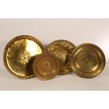 Four embossed brass chargers of floral motif,