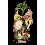 A Staffordshire pearlware figure group 'Bird Catcher' with a couple seated above a waterfall,