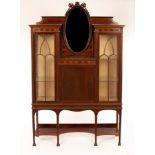 An Edwardian mahogany and inlaid display cabinet with oval mirror back above a cupboard and flanked