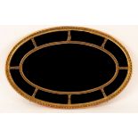A Regency style oval gilt wood sectional wall mirror with beaded details and moulded surround,