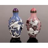 Two Peking glass cameo snuff bottles, one decorated eagles on branches to a blue ground,