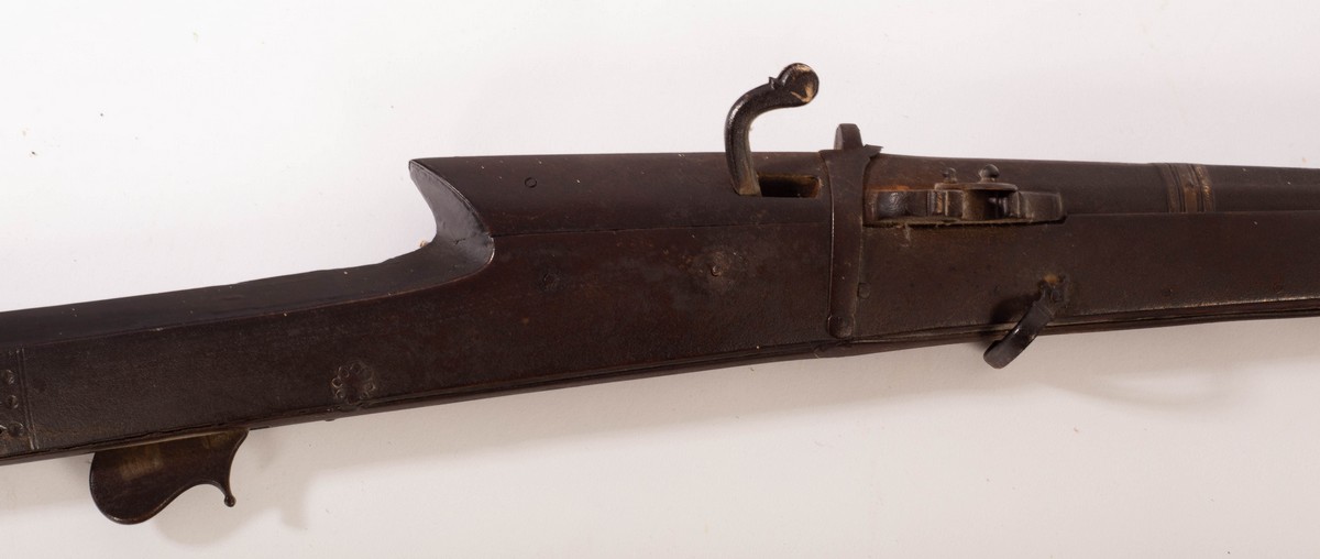 An 18th Century matchlock rifle with a walnut stock and octagonal steel barrel, mount and a ramrod,