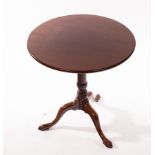 A circular mahogany table on a turned column and tripod support,