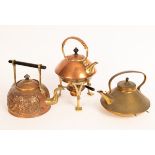 A copper and brass kettle on stand with rattan handle and two other kettles,