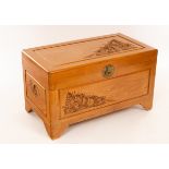 A 20th Century Oriental camphor wood chest with carved decoration to the top and sides,