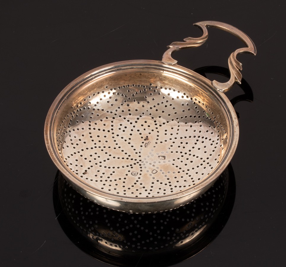 A George III silver strainer, London 1762, with pierced handle and clip, 15cm wide,