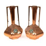 A pair of Arts & Crafts copper vases with straight handles,