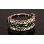 An Art Deco style day and night ring, set with green, red and white pastes in white metal,