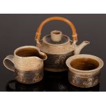 Mary Rich (1940-2022), stoneware tea service comprising teapot with cane handle, jug and sugar bowl,
