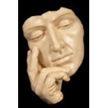 A contemporary wall sculpture of a face resting on a hand,