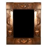 An Arts & Crafts style copper mirror, the frame embossed heart motifs, 46.5cm x 38.