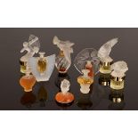 Nine miniature perfume bottles designed by Lalique, some with glass stoppers,