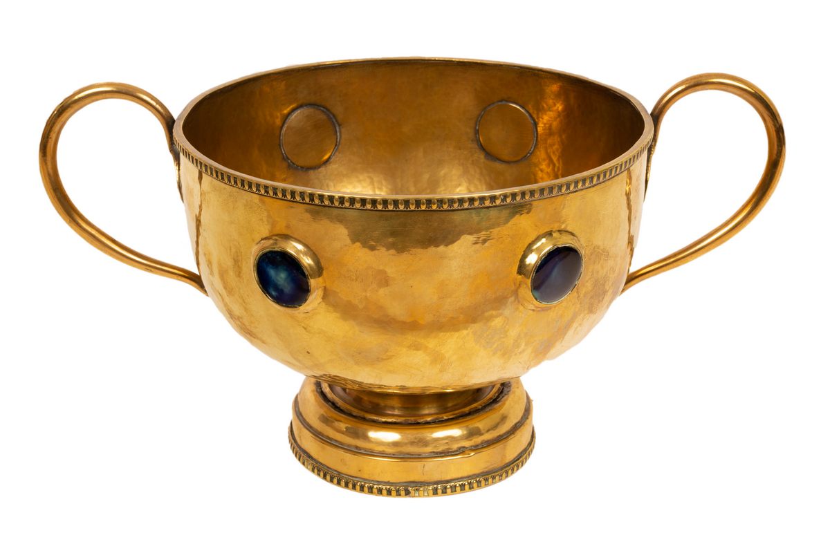 An Arts & Crafts brass twin handled pedestal bowl with Ruskin style mounts, hammered finish,