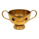 An Arts & Crafts brass twin handled pedestal bowl with Ruskin style mounts, hammered finish,