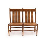 William Birch, an oak two chair back rush seat Arts & Crafts settle,
