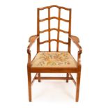 A walnut armchair of Cotswold School design with trellis back and loose trap seat,