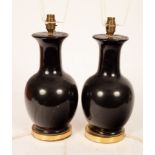 A pair of ebonised vase-shaped table lights with shades,