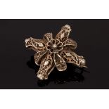 An Eastern white metal brooch of cross form, the central flowerhead motif with filigree decoration,