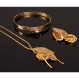 A 9ct gold necklace, bangle and brooch with lily motifs, all bearing import marks, approximately 20.