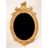 An early Victorian giltwood oval wall mirror with shell, floral and scroll surmount,