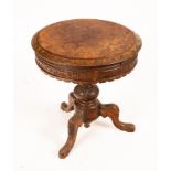 A mid Victorian circular figural walnut worktable with fluted interior,
