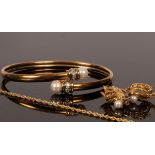 A 10k gold bangle with cultured pearl terminals and diamond collars,