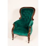 A mahogany armchair with deep button back, on turned front legs,