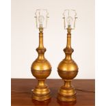 A pair of gilt table lamps of turned form,