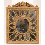 A giltwood wall mirror with scrolling swan neck surmount and sunburst frame,