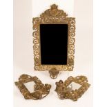 A gilt brass Florentine style wall mirror with mask head surmount and two matching mirror backed