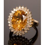 A citrine and diamond cocktail ring, the large oval citrine to a double border of small diamonds,
