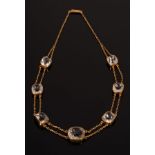 A rock crystal necklace, the seven graduated cushion-shaped stones on a two strand gold necklace,