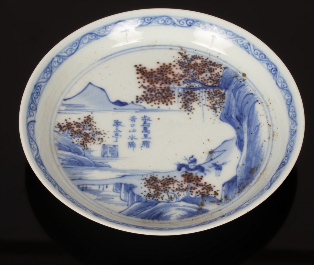 A small Chinese porcelain saucer, Qinghua Youlihong, 20th Century, with figures in landscapes,
