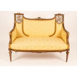 A 19th Century giltwood two-seater sofa with carved cresting and pierced trellises to the sides,