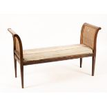 A mahogany window seat with scroll ends, cane panels and upholstered cushion, on square taper legs,