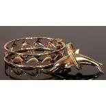 An Italian bi-colour 14k gold bangle with pierced textured dolphin decoration,