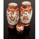 A pair of Imari baluster vases, 24cm high, another with slender neck, all on stands,