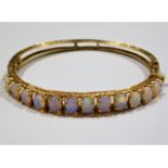 A 14ct gold bracelet set with 12 opals, measuring