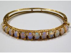 A 14ct gold bracelet set with 12 opals, measuring