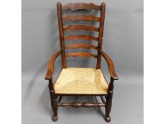 An 18thC. ladder back chair with rush seat, 41.25i