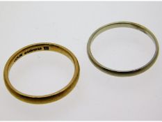 A 9ct gold band, size O twinned with a white metal